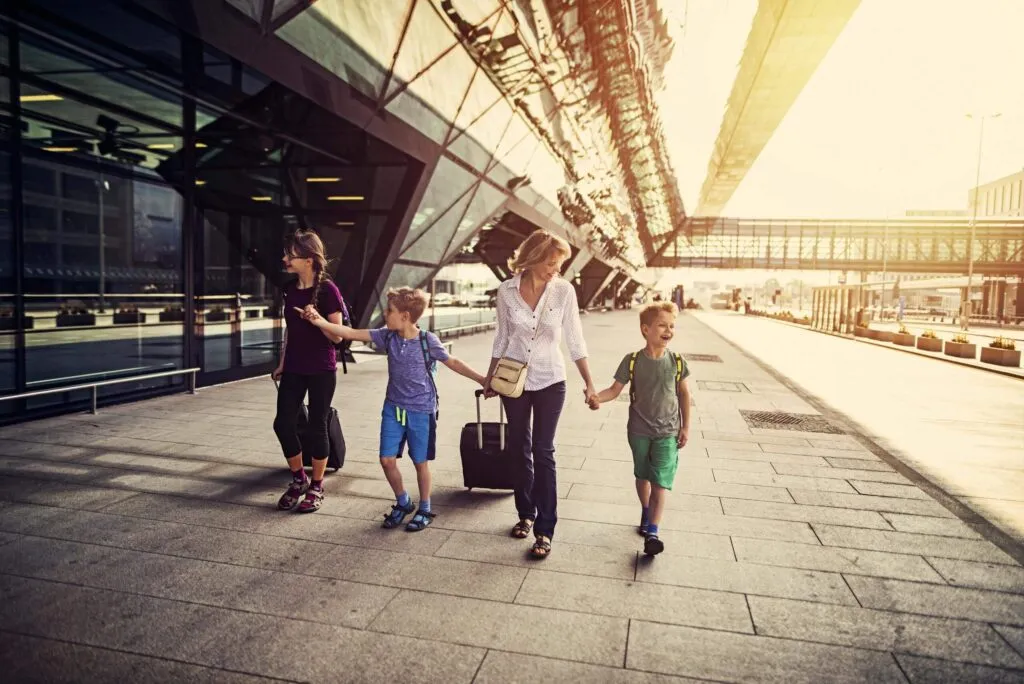 Mother with 3 kids walking at the airport