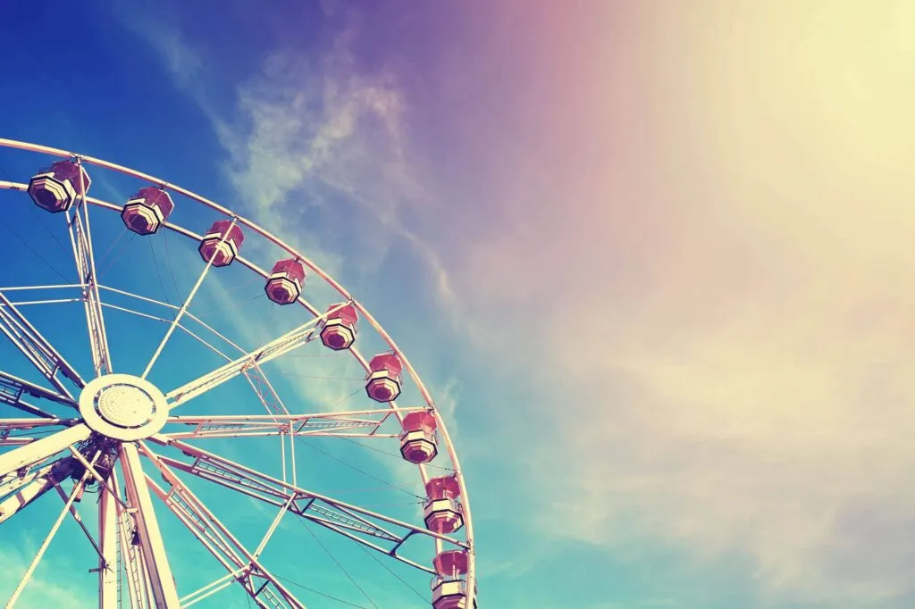 Vintage stylized ferris wheel at sunset, space for text.