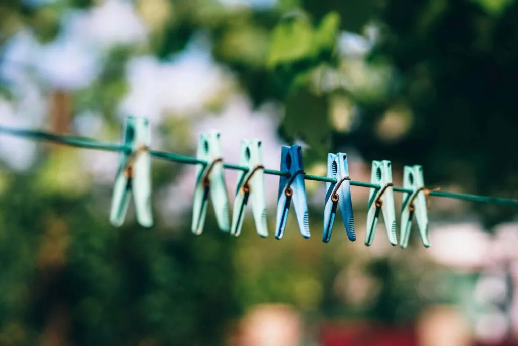 Green and blue pegs on a line. Photo by FancyCrave on Unsplash