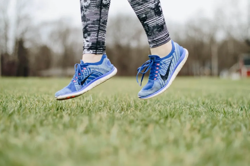 Nike shoes jumping in green field