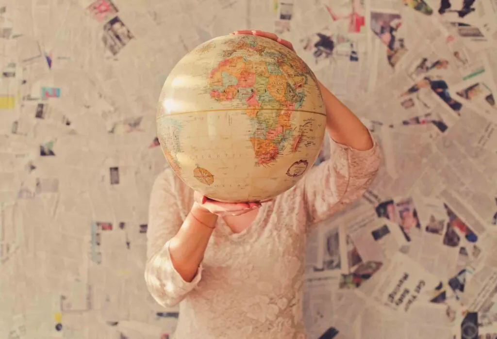 Girl holding a Globe. Photo by Slava Bowman on Unsplash