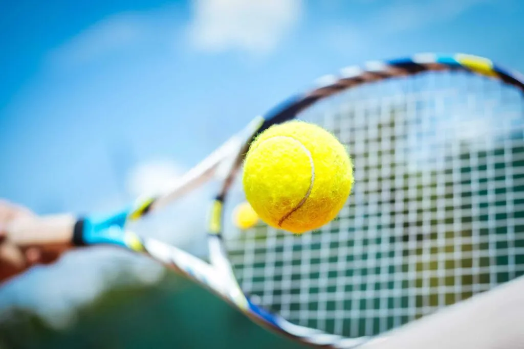 Close up of tennis ball and tennis racquet