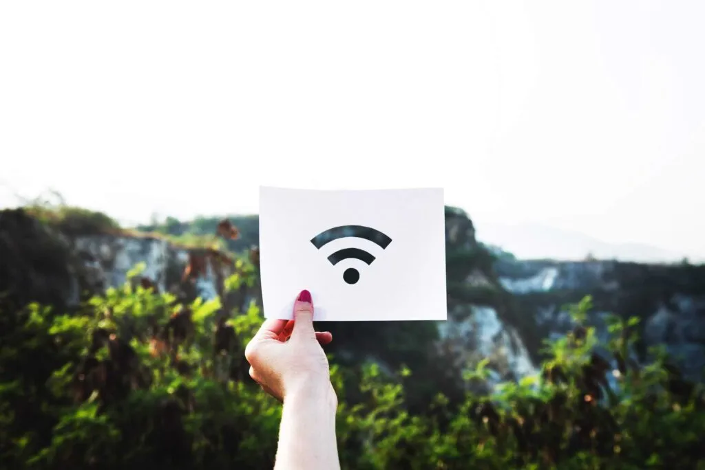 Woman holding up WiFi sign. Photo by RawPixel on Unsplash